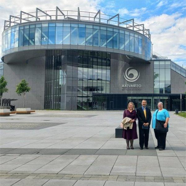 three people standing in front of building at the University of Ostrava