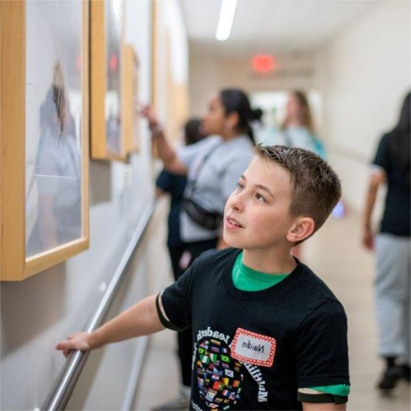 Endeavor Elementary School students look at the artwork in the tunnel that leads from Kirkhof Center to the Mary Idema Pew Library.